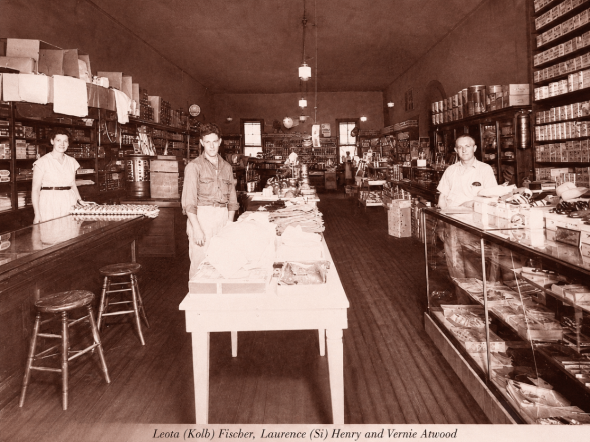 Interior of a Lincoln general store with shelves of goods and three clerks