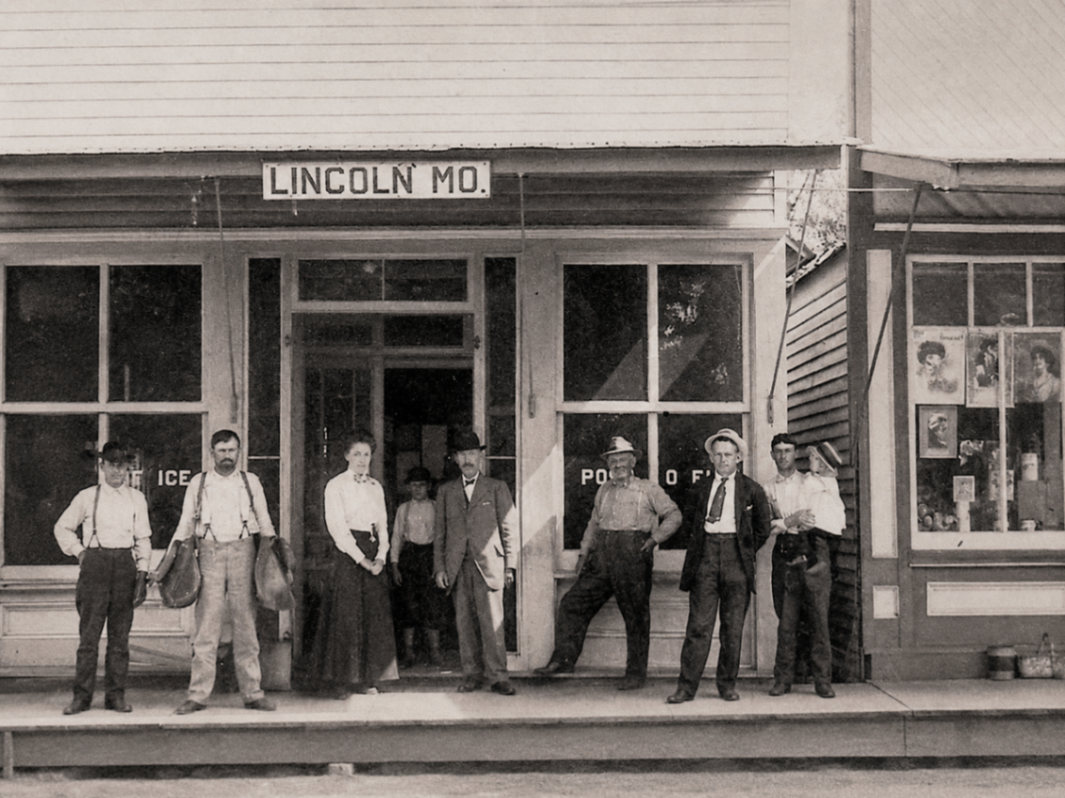 Townspeople standing on the boardwalk outside a Lincoln, Missouri storefront